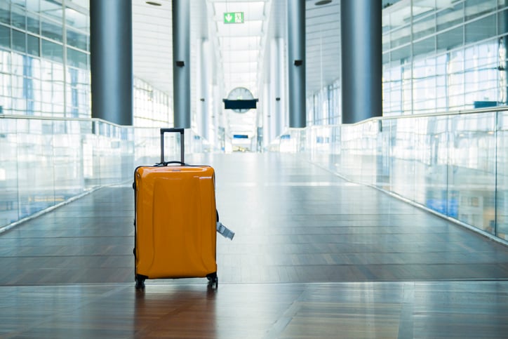 yellow unclaimed luggage in empty airport terminal