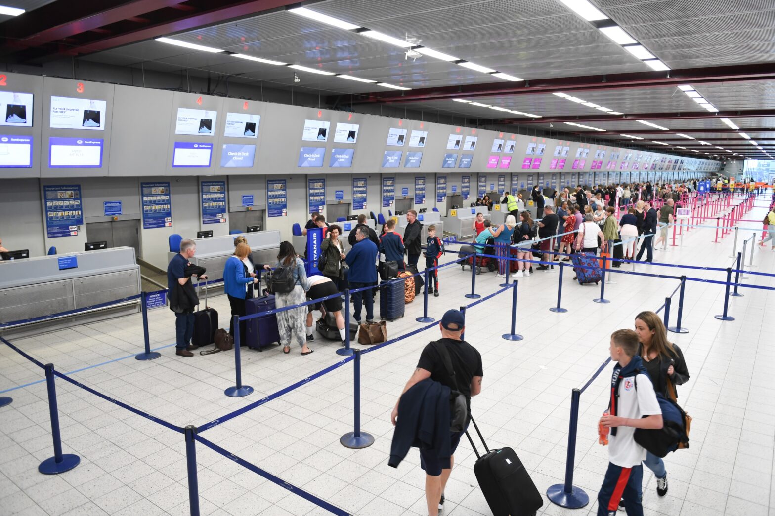 people standing in line at the checkout as airlines make cuts to New York to reduce flight delays this summer