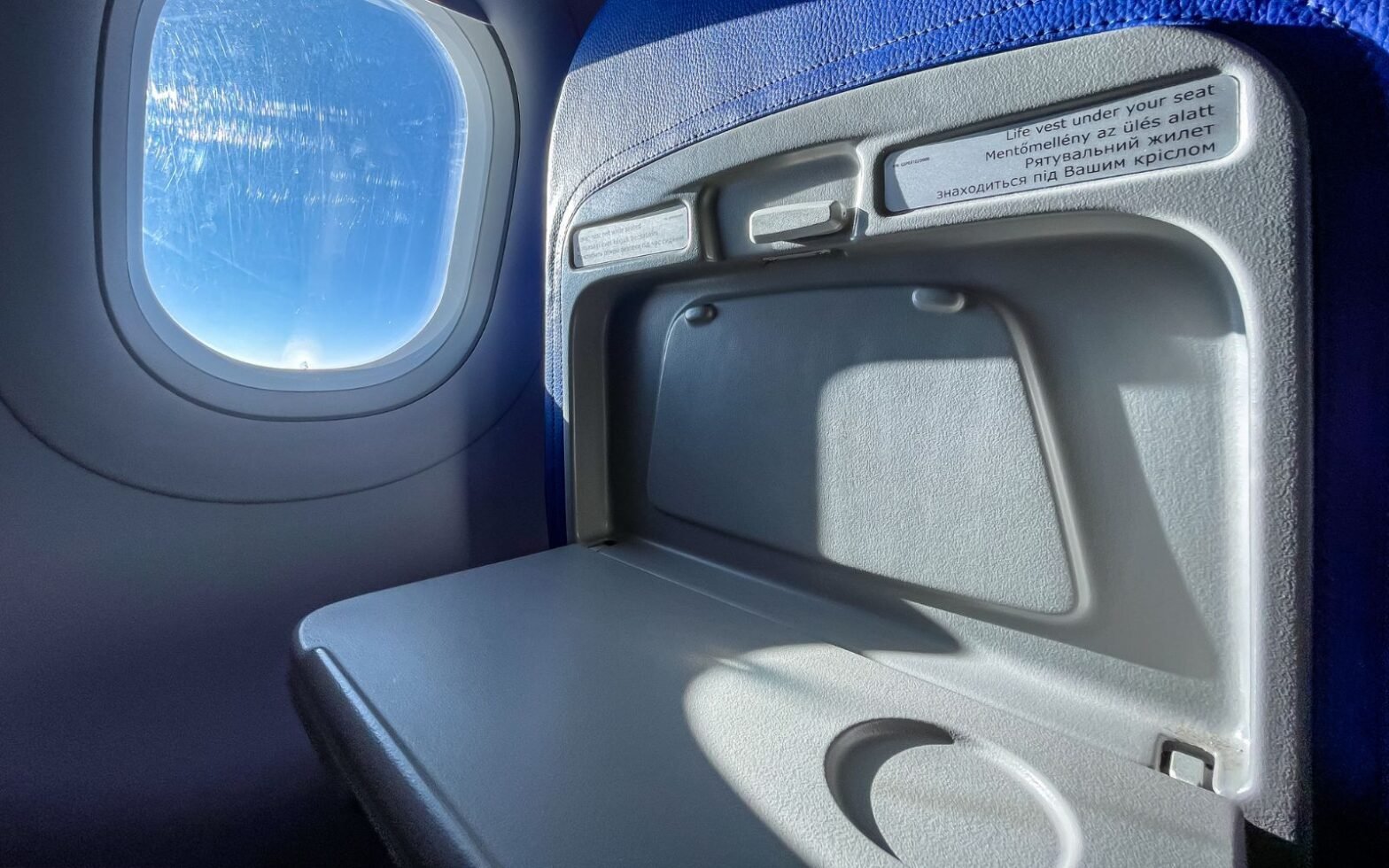 airplane tray travel on aircraft - woman places bare feet on tray table during flight