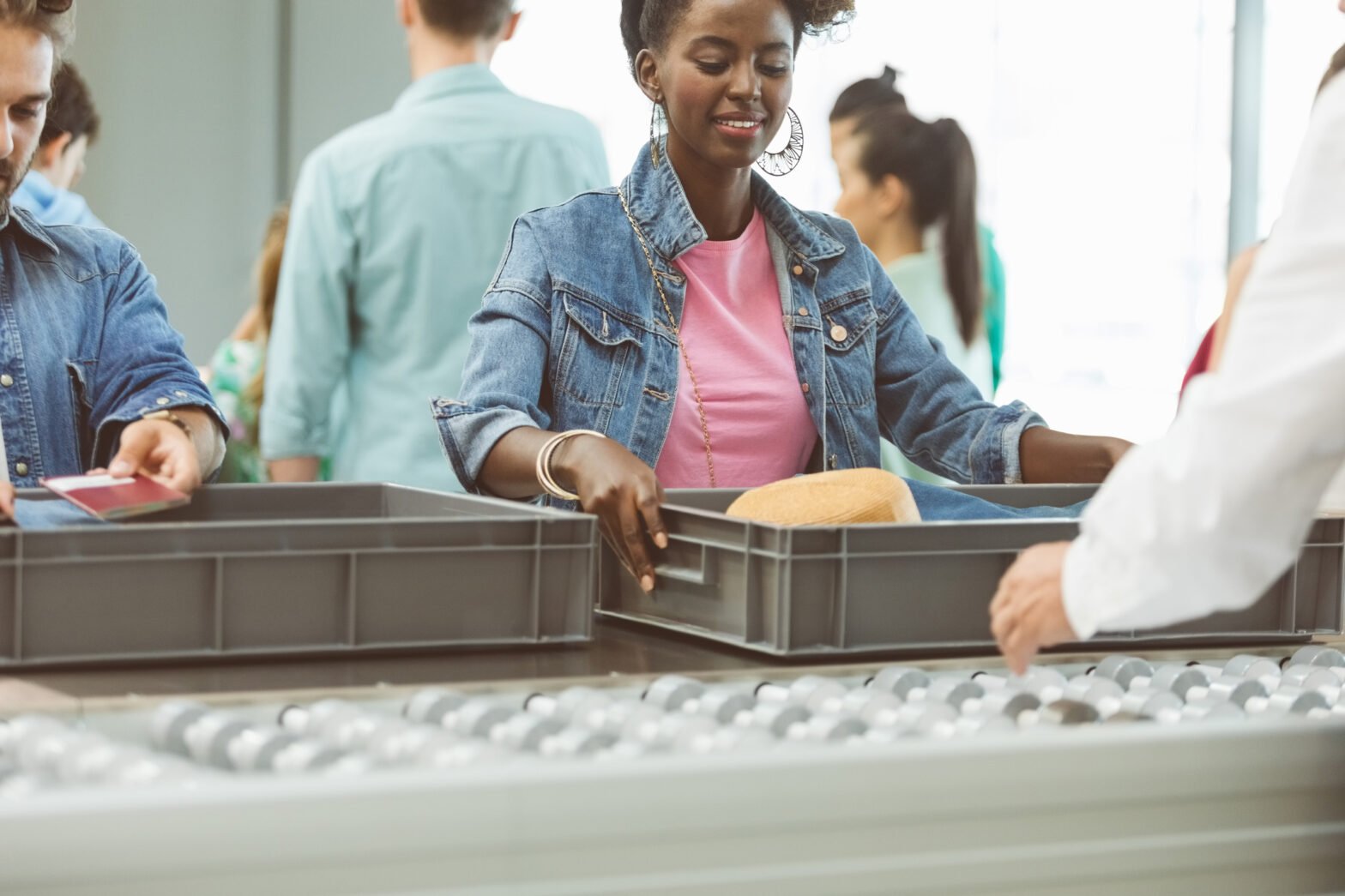 Woman picking container while standing by man at security check in airport