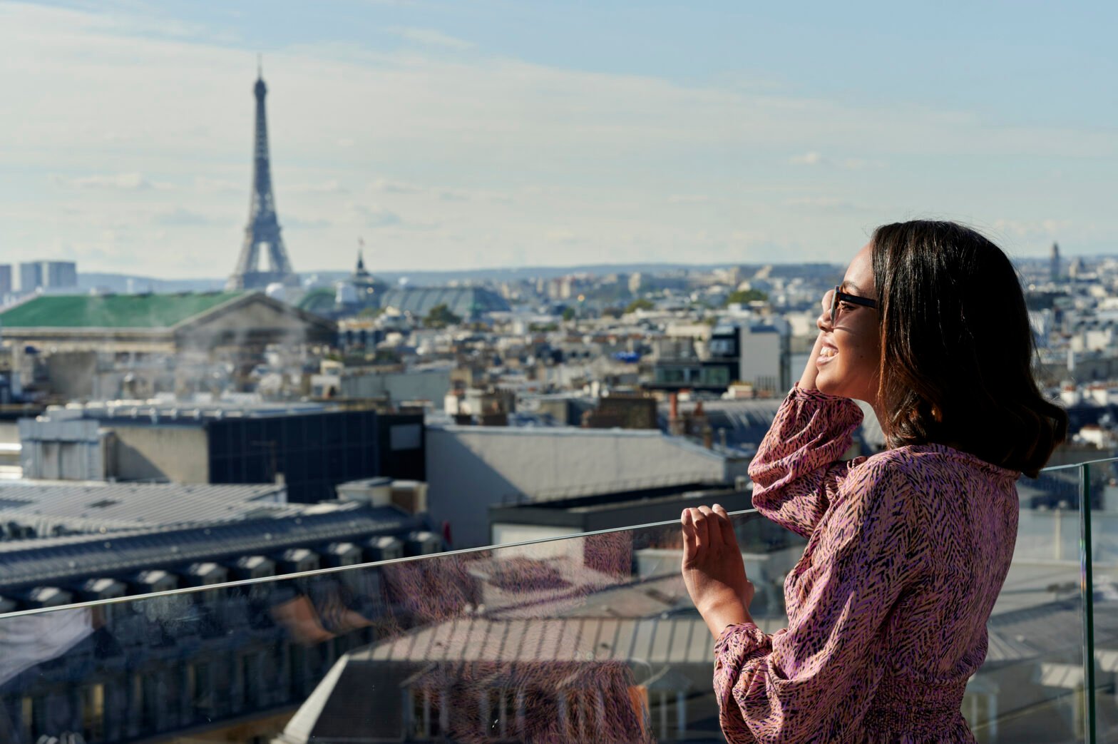 Tourist looking at Eiffel Tower from rooftop, Paris, France