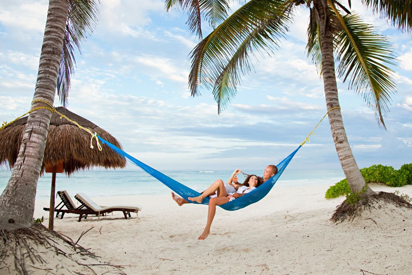 couple laying on hammock on beach in Mexico