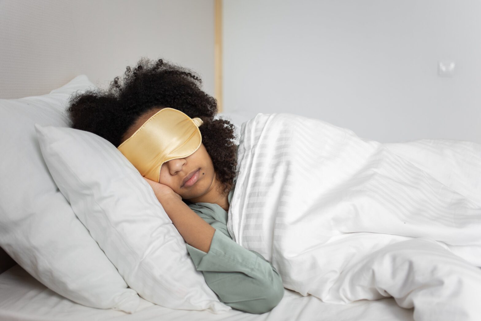 woman sleeping with eye mask in bed