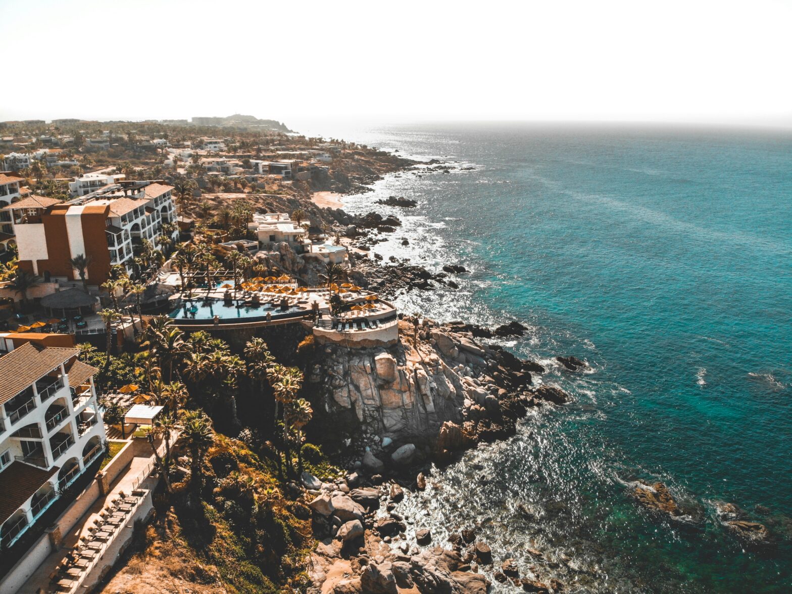 overhead drone view of the blue coastal shores and luxury hotels in Cabo San Lucas, Mexico
