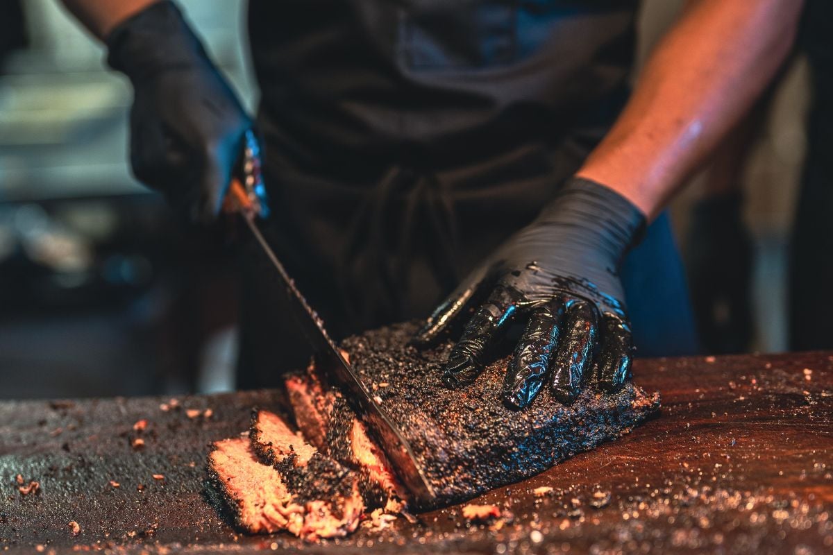 BBQ chef prepares a serving of smoked Brisket