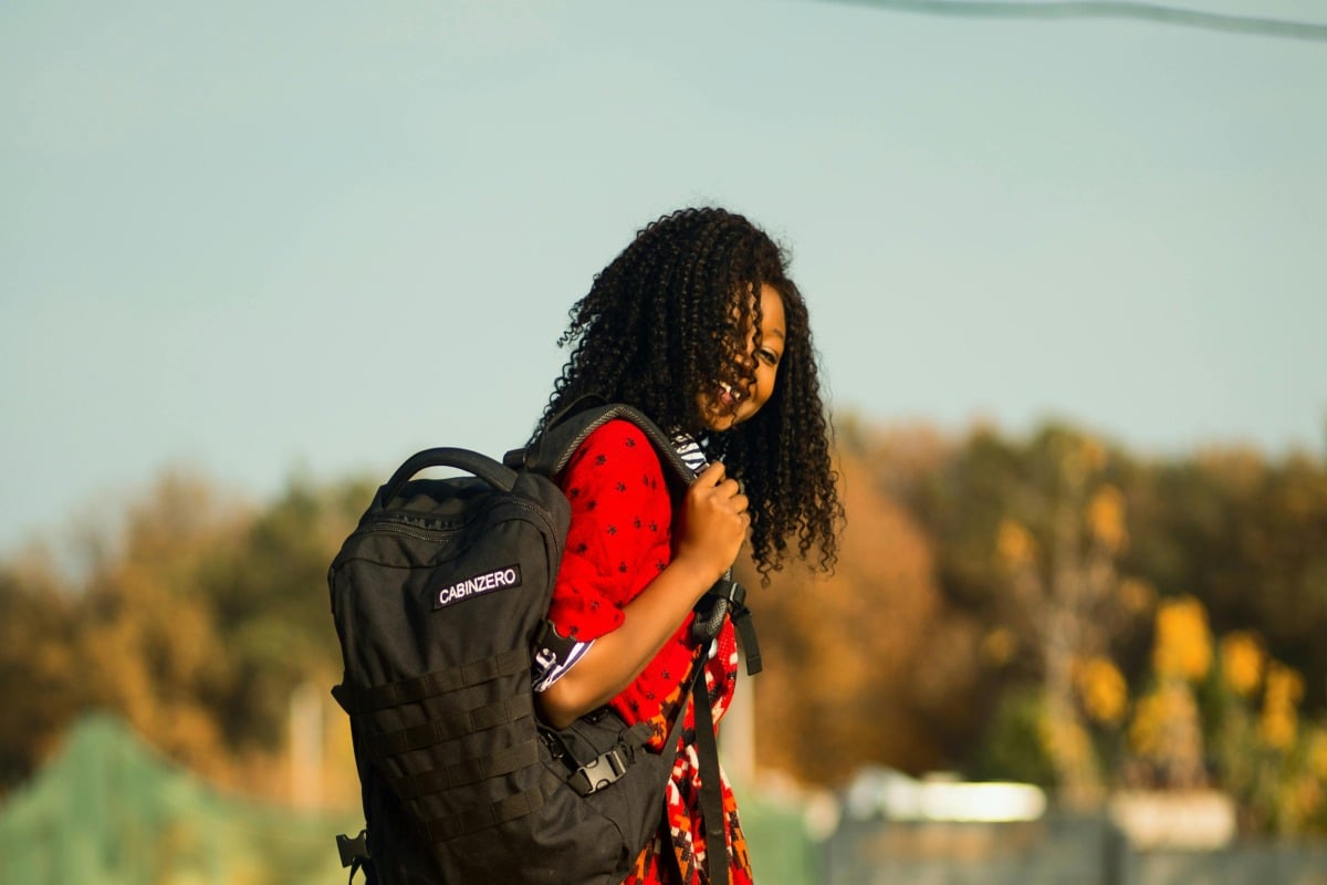 Woman carrying a black backpack.
