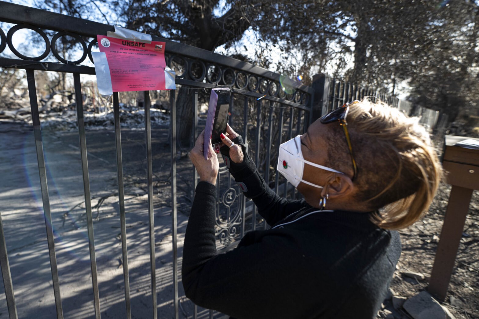 Altadena resident takes a picture of marker left on her property gate, after house completely burned down from the Eaton Fire