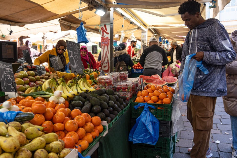 A man buys fruit at the market in Noailles neighbourhood of Marseille, southern France