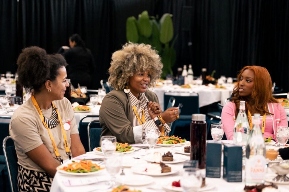 three women discussing topic at conference luncheon
