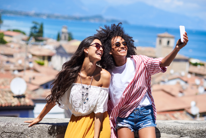 Two multi ethnic friends making selfie at Sirmione,Italy