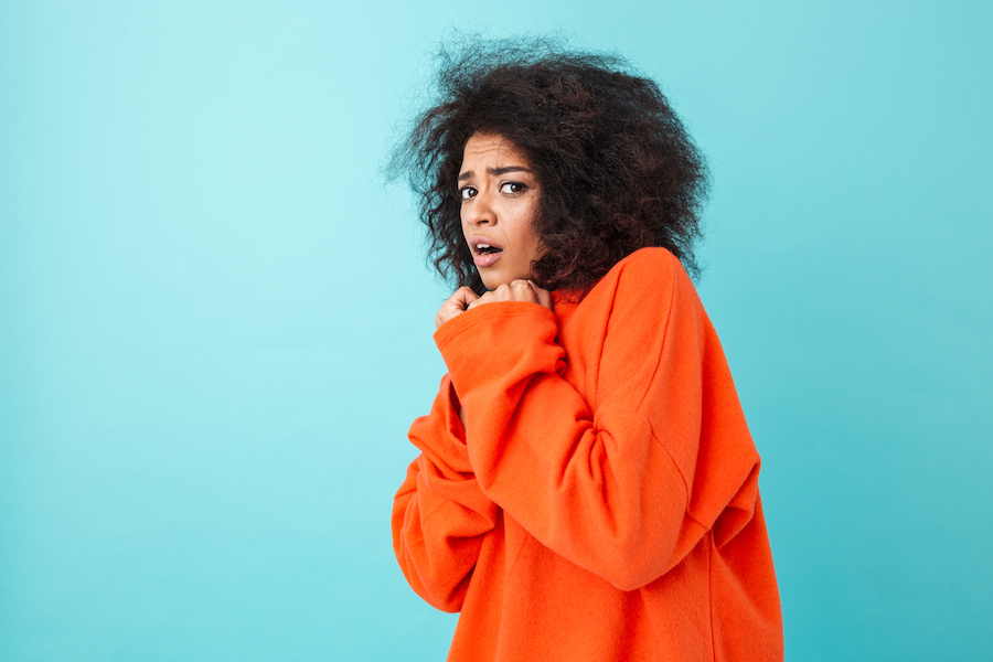 frightened woman on bright blue backdrop