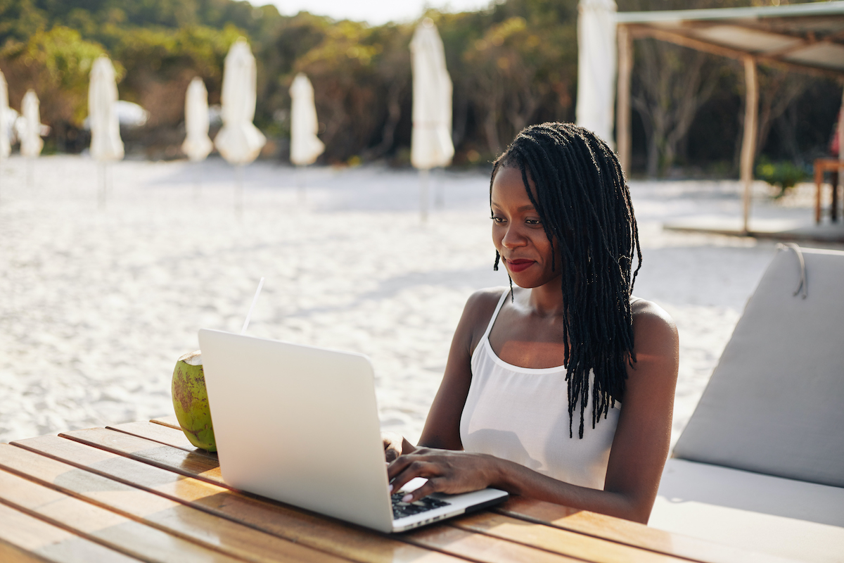 Woman working on laptop outdoors.