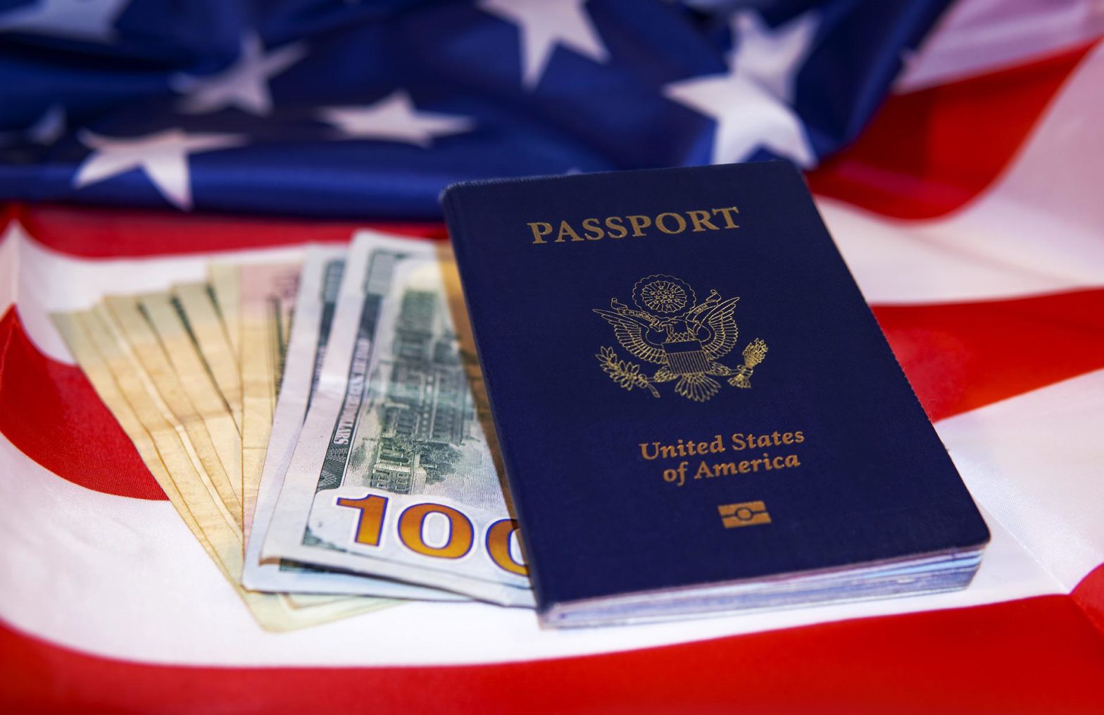 passport with hundred dollar bills laying on American flag - where can you travel without a passport