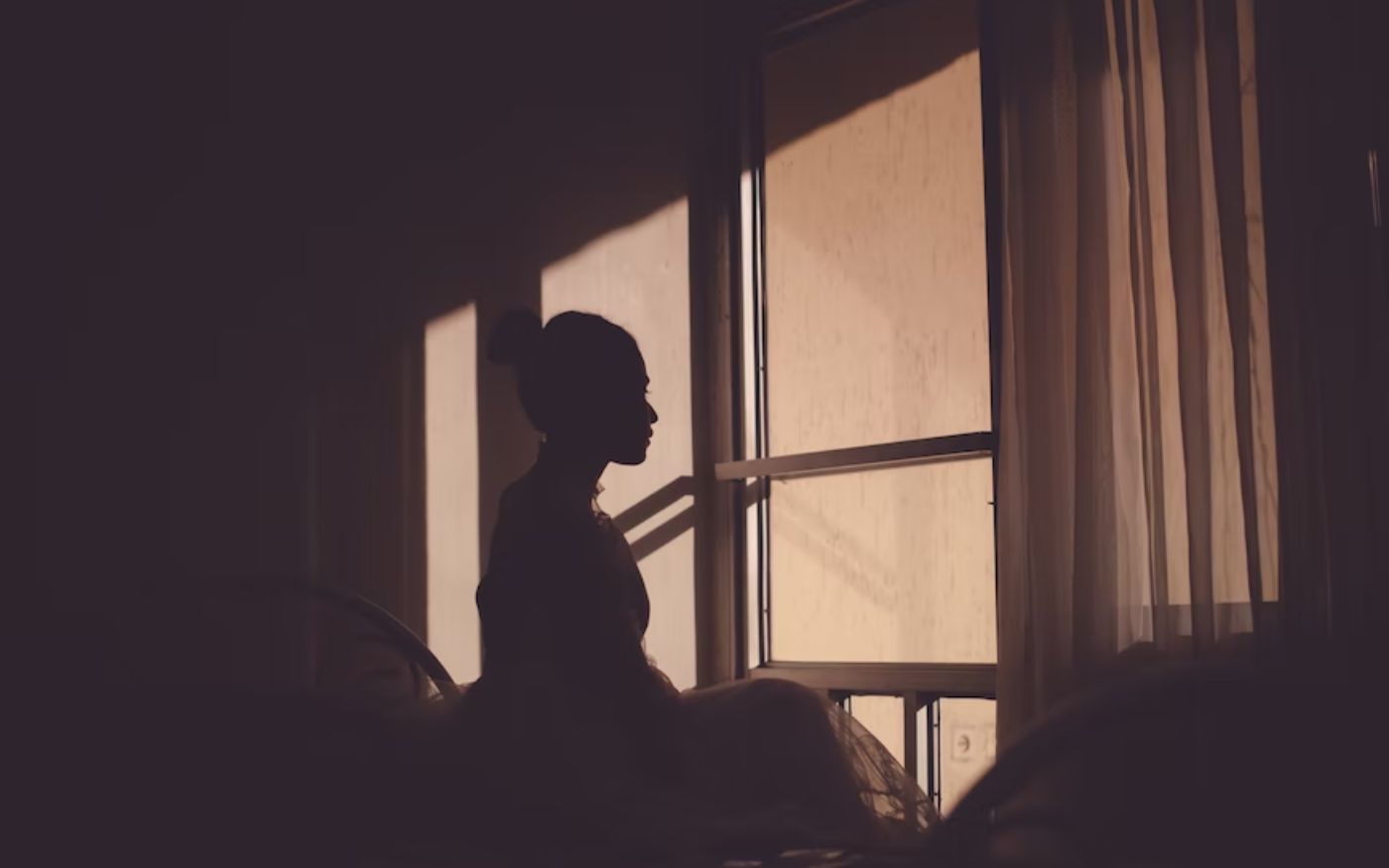 image of bride sitting in dark room staring out the room - representation of American woman kidnapped by family to arrange forced marriage