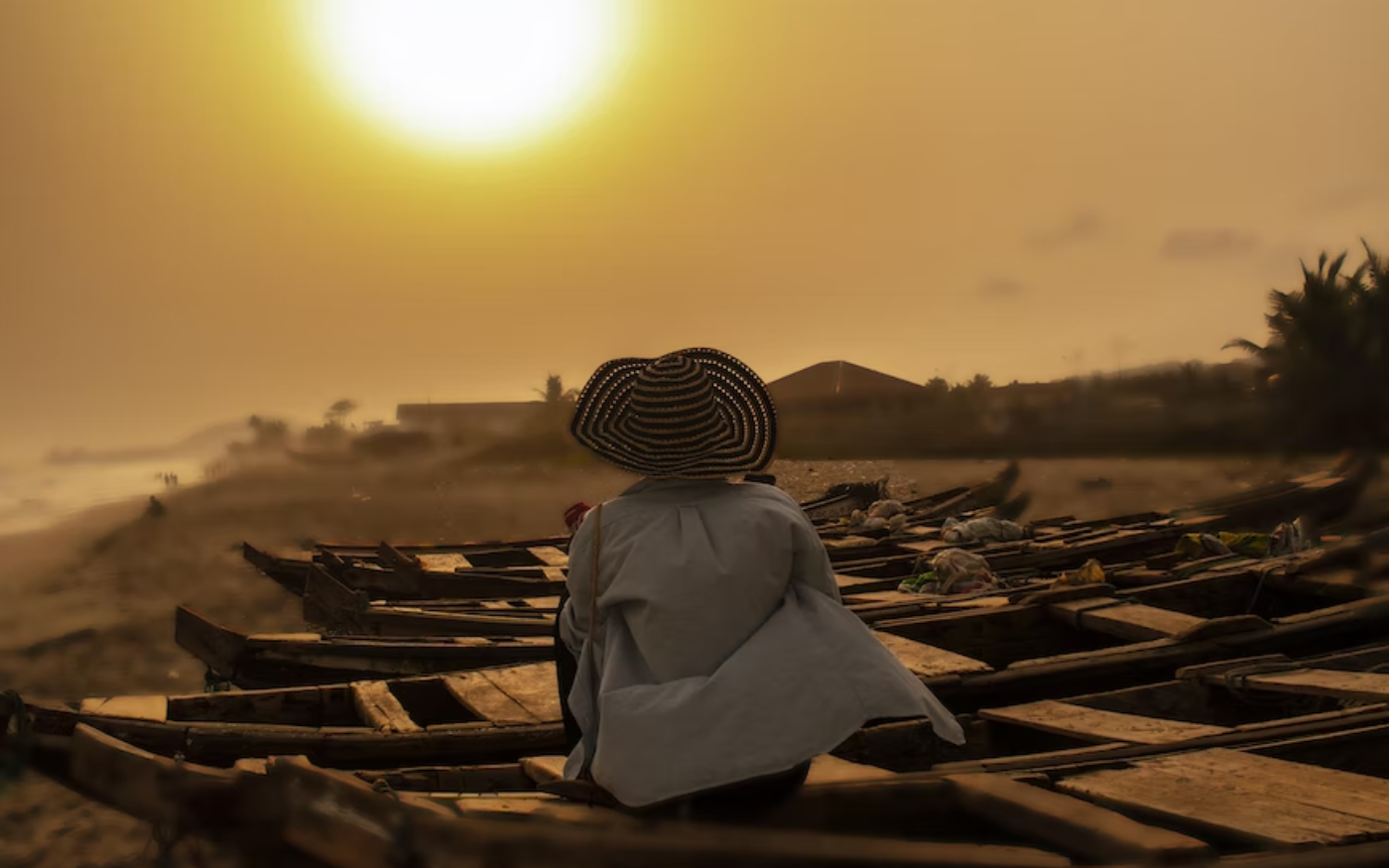 woman sitting on boat along the beach shoreline in Ghana