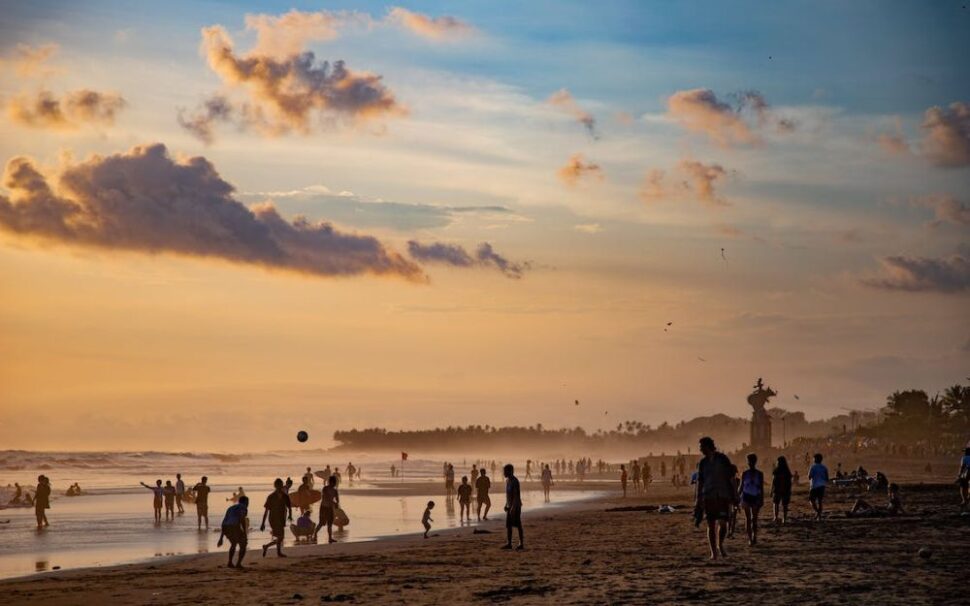 Beach in Bali with tourists at sunset