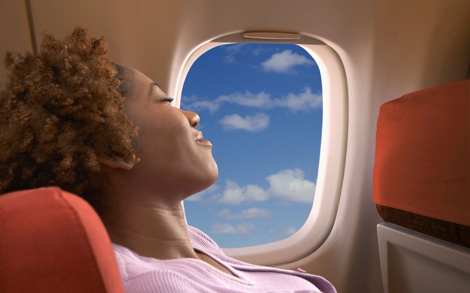 woman relaxing in economy seating - how to make economy more comfortable