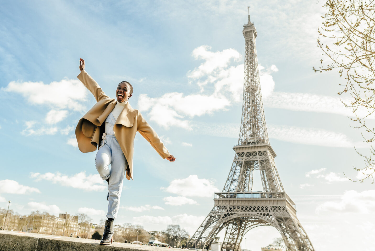 Check out this curated Paris 3 day itinerary for the best trip. Pictured: an excited woman jumping in front of the Eiffel Tower.