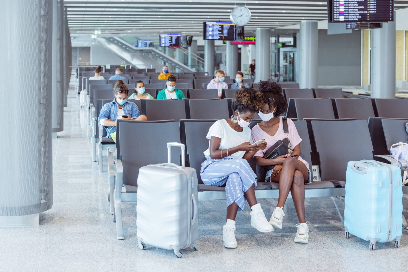 two Black women wearing masks in an airport