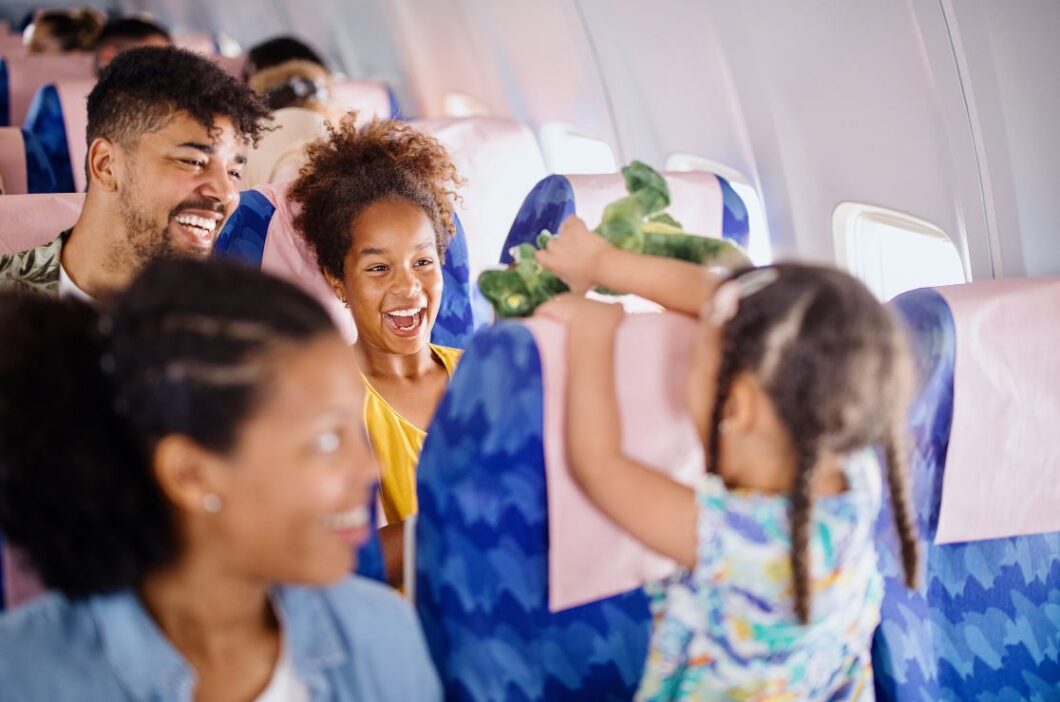 child smiling at woman on a plane - are adults in favor of child-free sections on public transportation