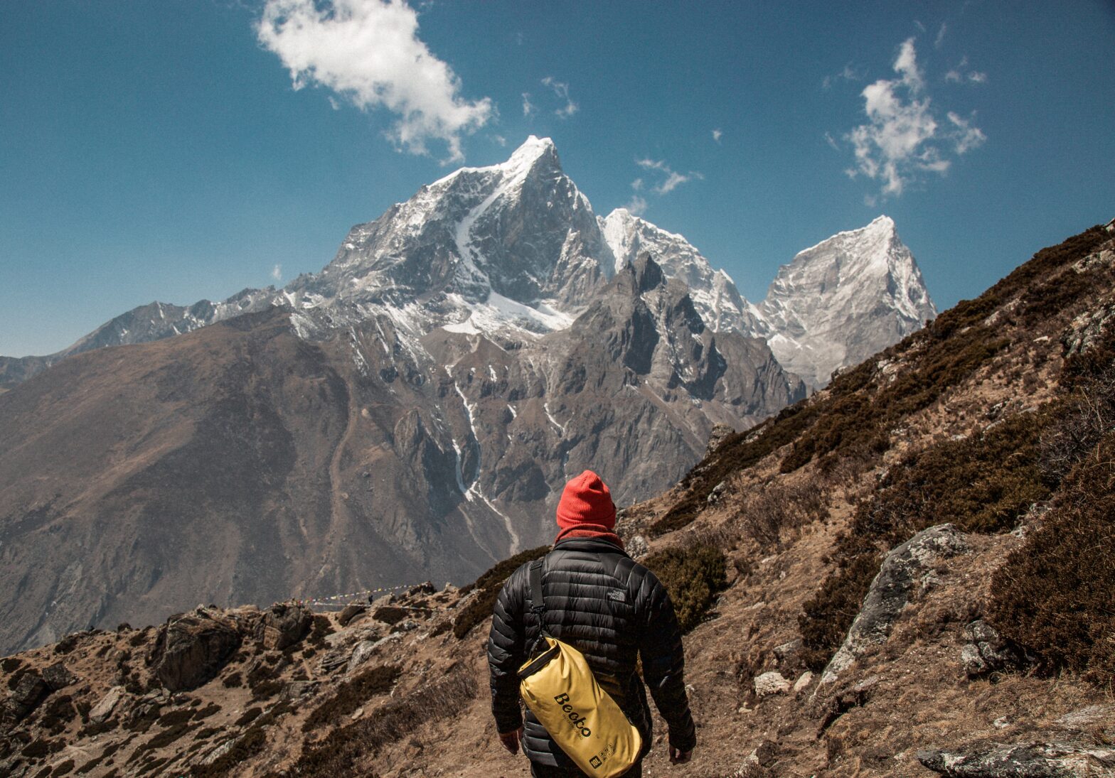 A hiker stands in front of Mount Everest