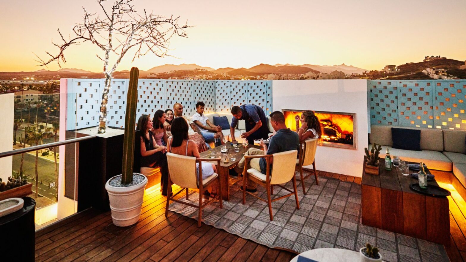 group of people having dinner outdoors during sunset