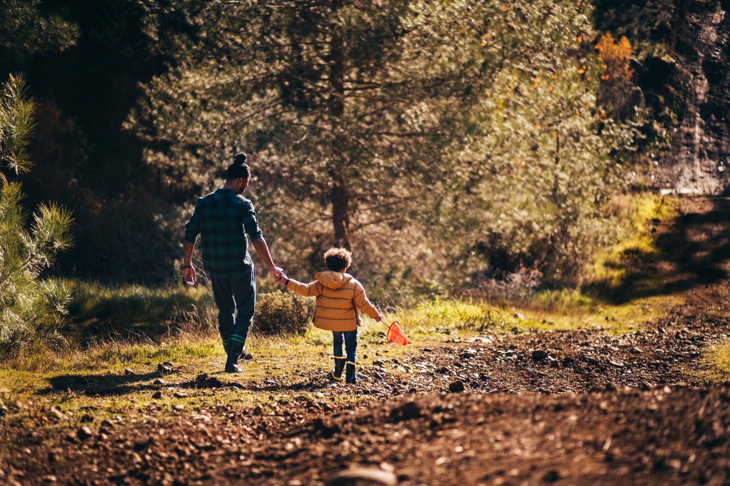 father and son playing outside in the fall