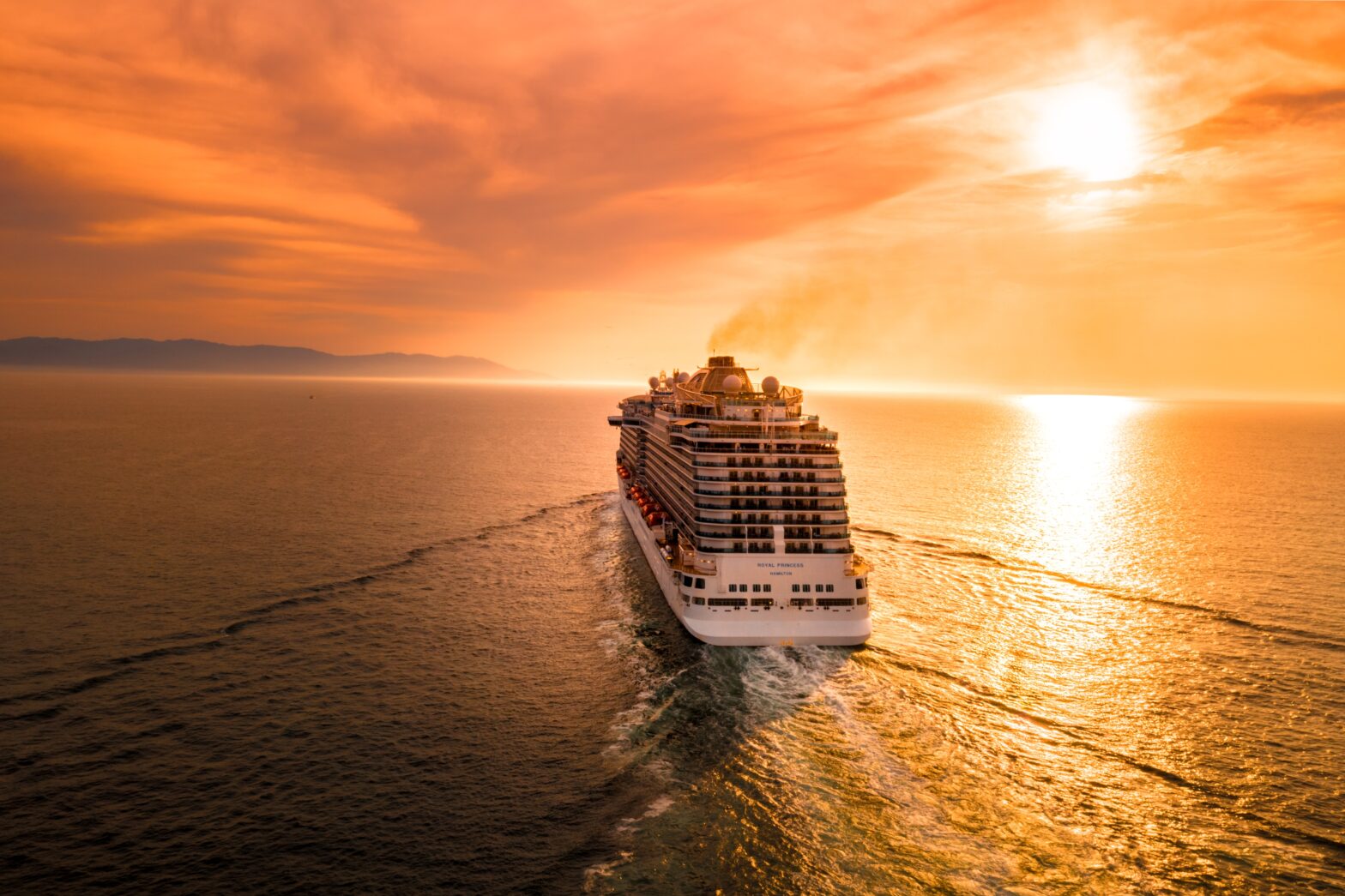 cruise ship sailing at sunset