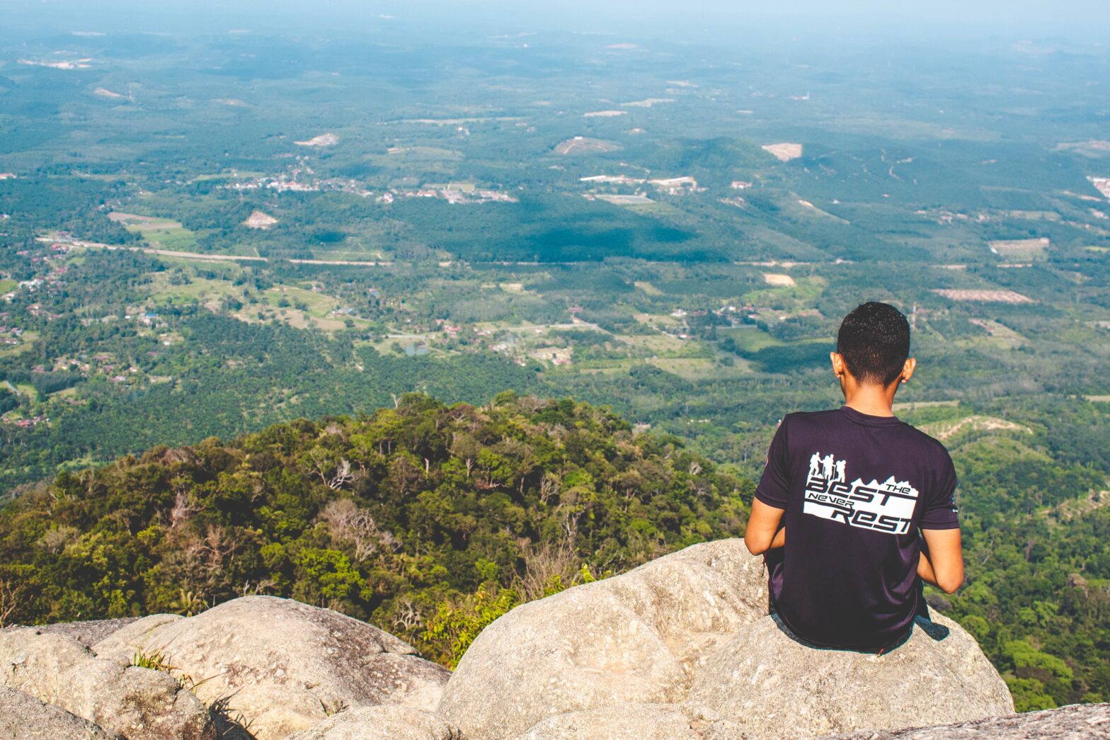 guy sitting on edge of mountain