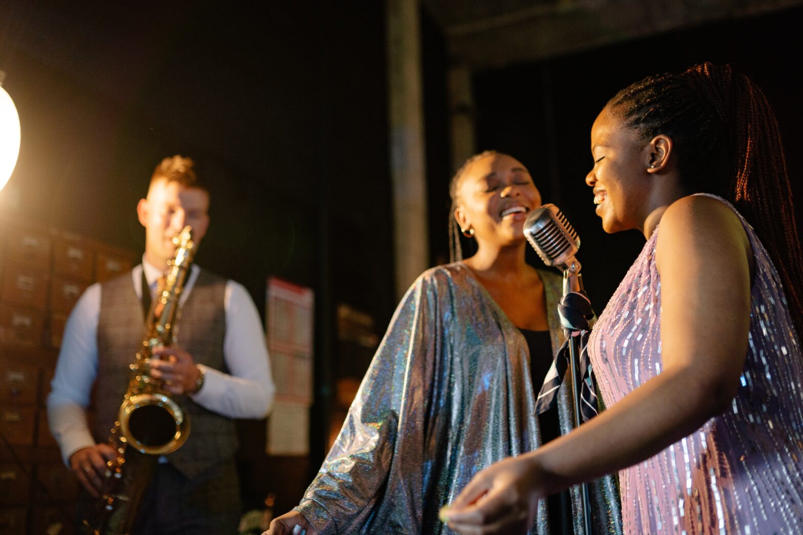 people singing and man playing saxophone