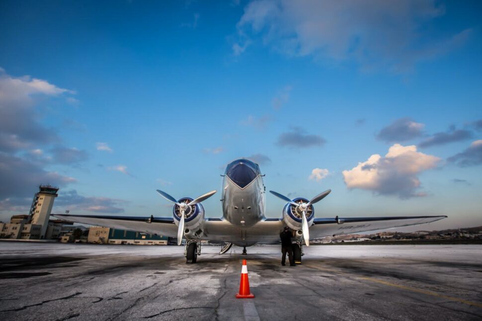 Check out the price differences between these Trusted Traveler Programs. Pictured: front view of a propeller plane on the tarmac.