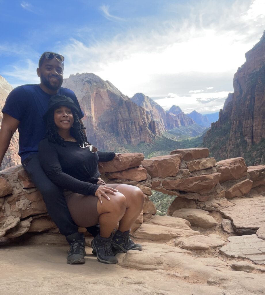 Black People Outside creators enjoying the ... outside. A hiking landscape and mountainous region behind them.