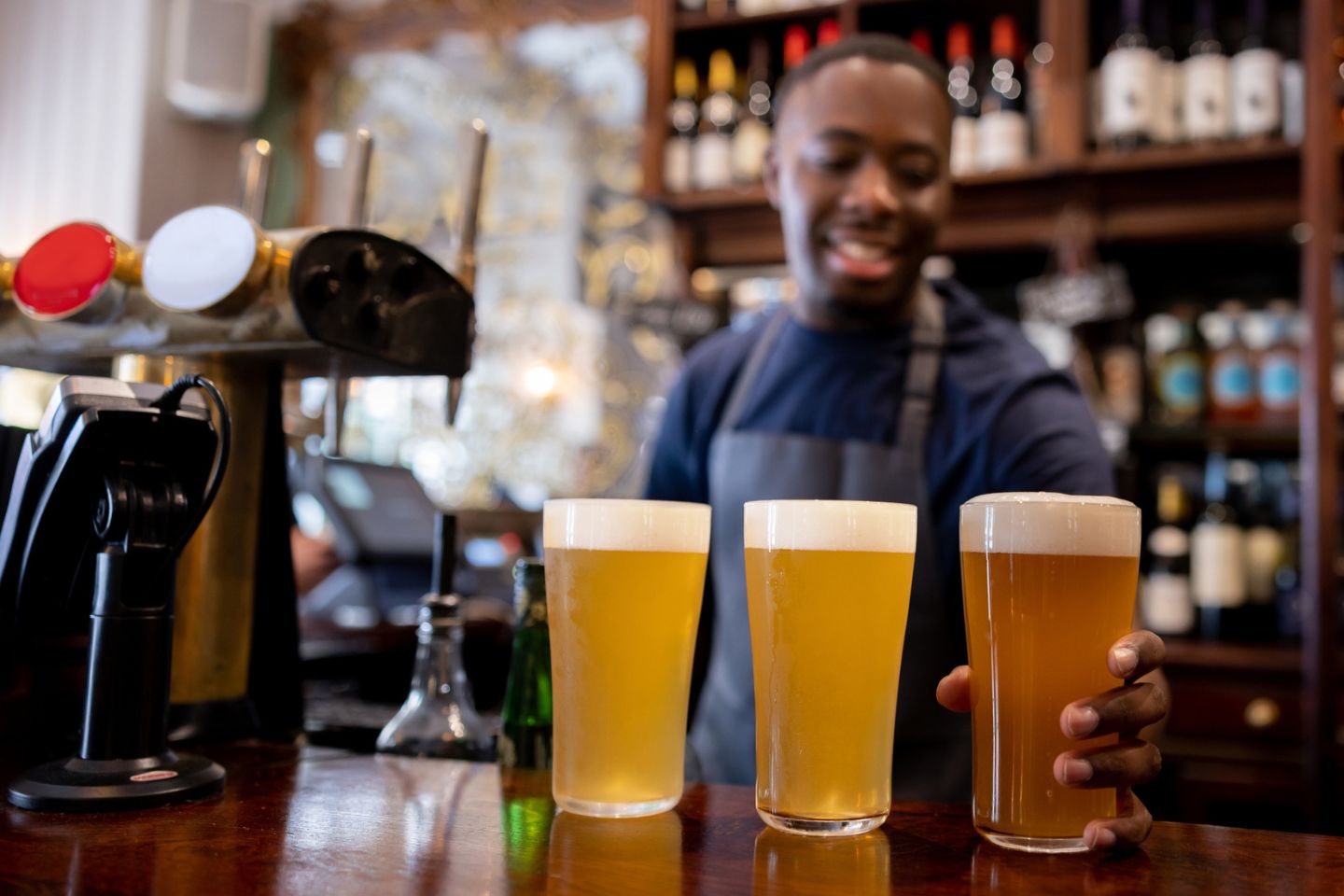 man pouring drinks at brewery