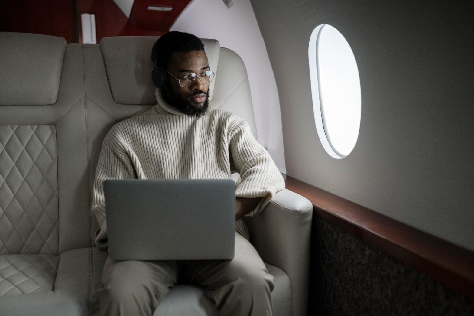 man looking out window on a plane