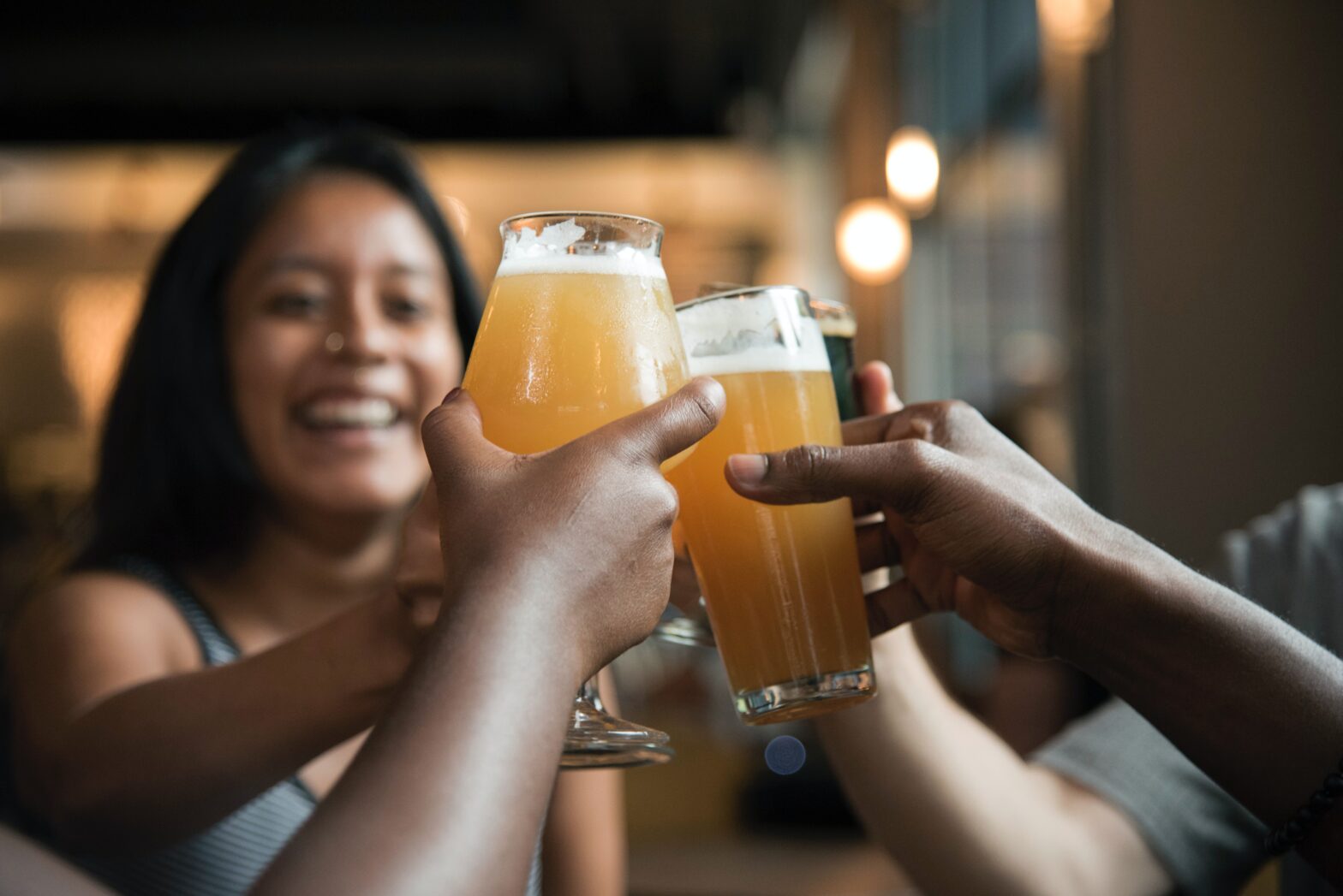 people toasting with beer in hand