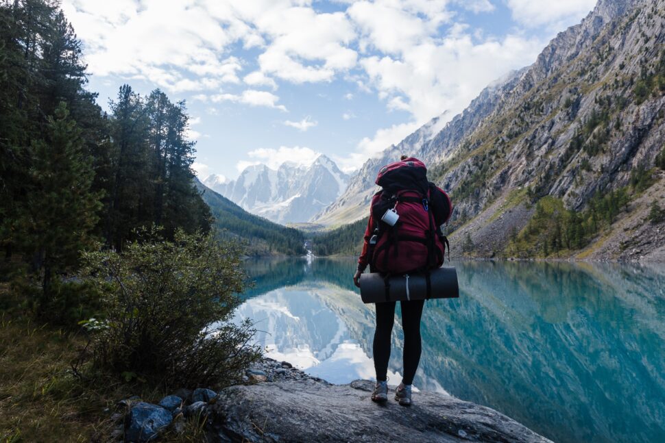 person backpacking near lake