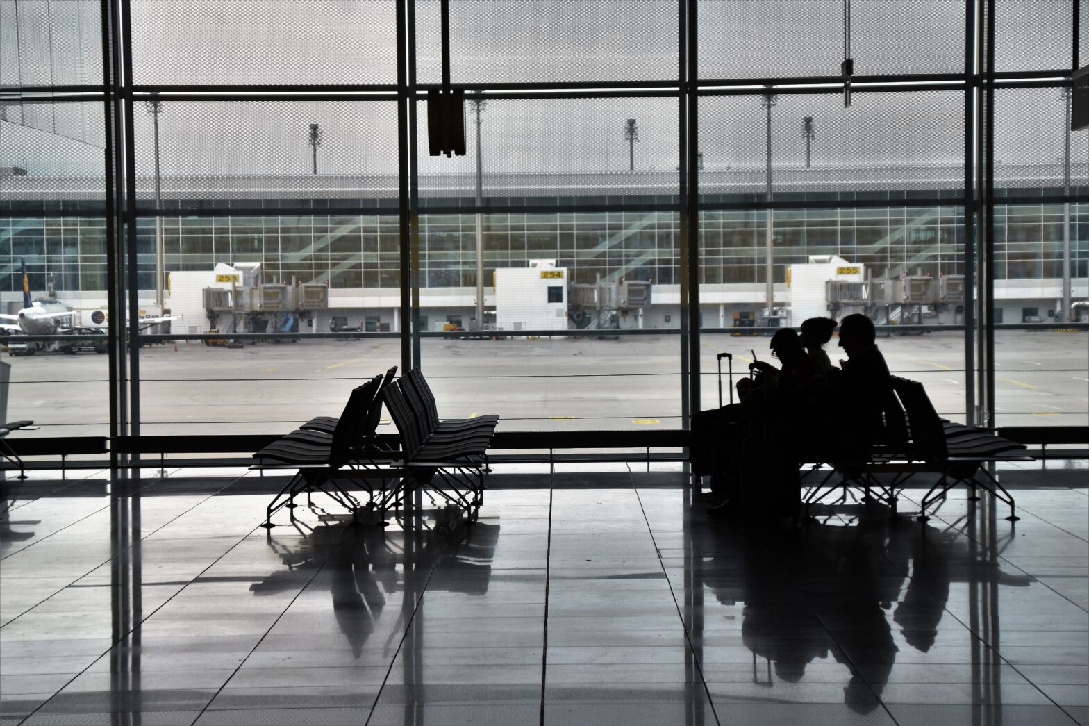 Learn more about the murals in Denver's International Airport that have caused conspiracies. Pictured: people waiting in the airport for a plane.