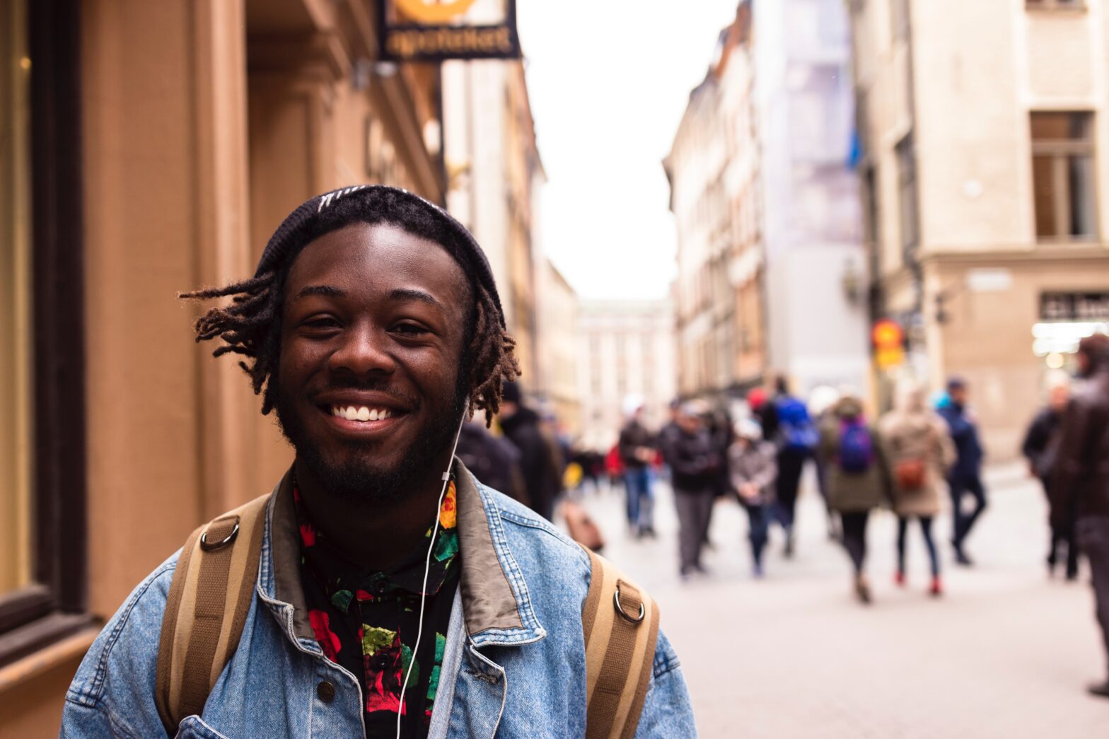 young Black man smiling while walking on street