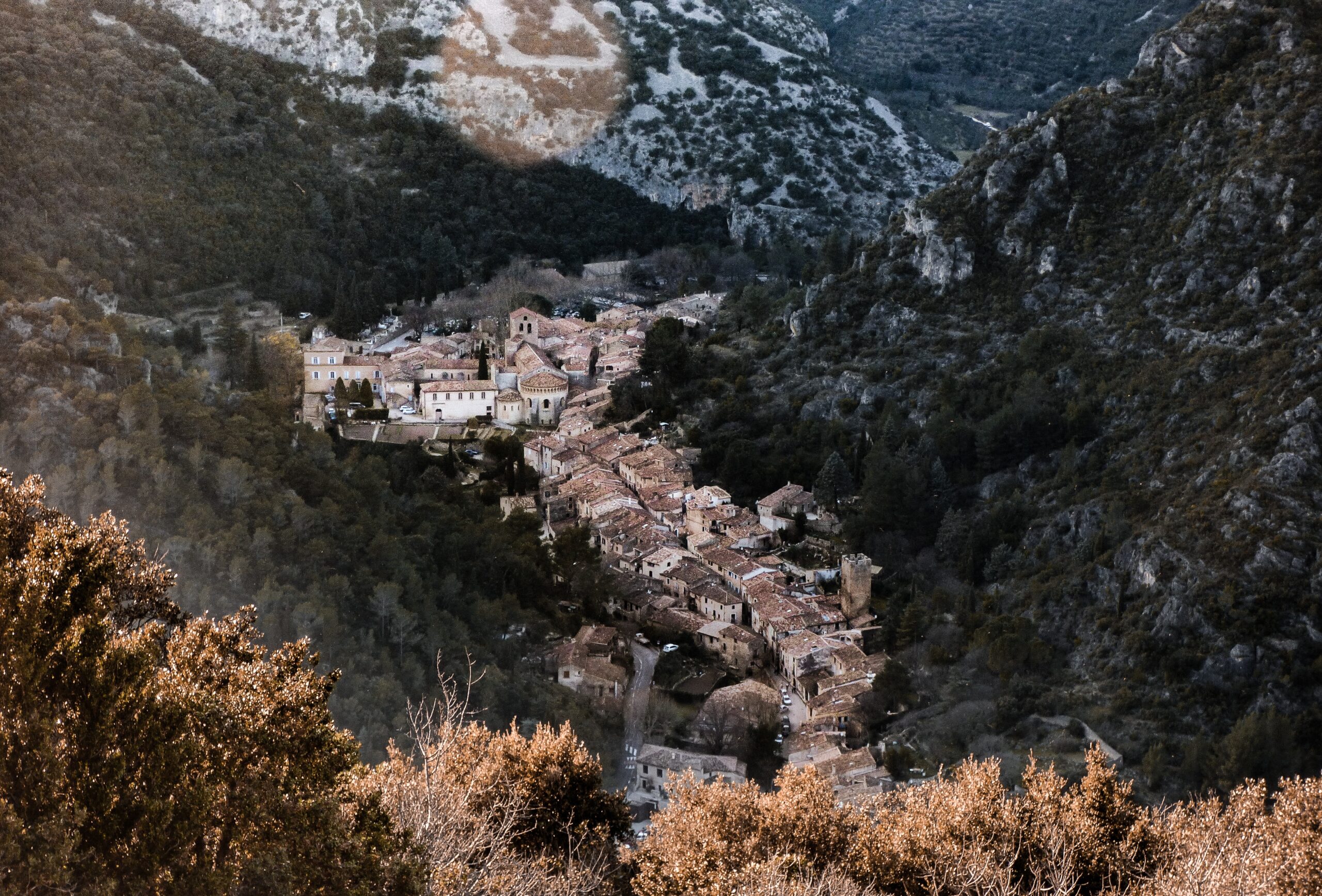 Occitanie is a southern region of France that is known for its historic attractions. 
Pictured: A town of Occitanie that is surrounded by large mountains 