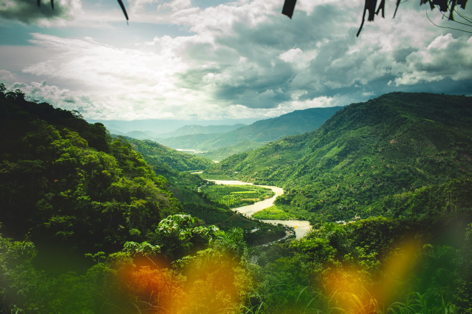 Peru is a stunning country with popular sights to see. Learn more about the safety level of the country. Pictured: A lush green valley, rainforest and distant mountains of Peru