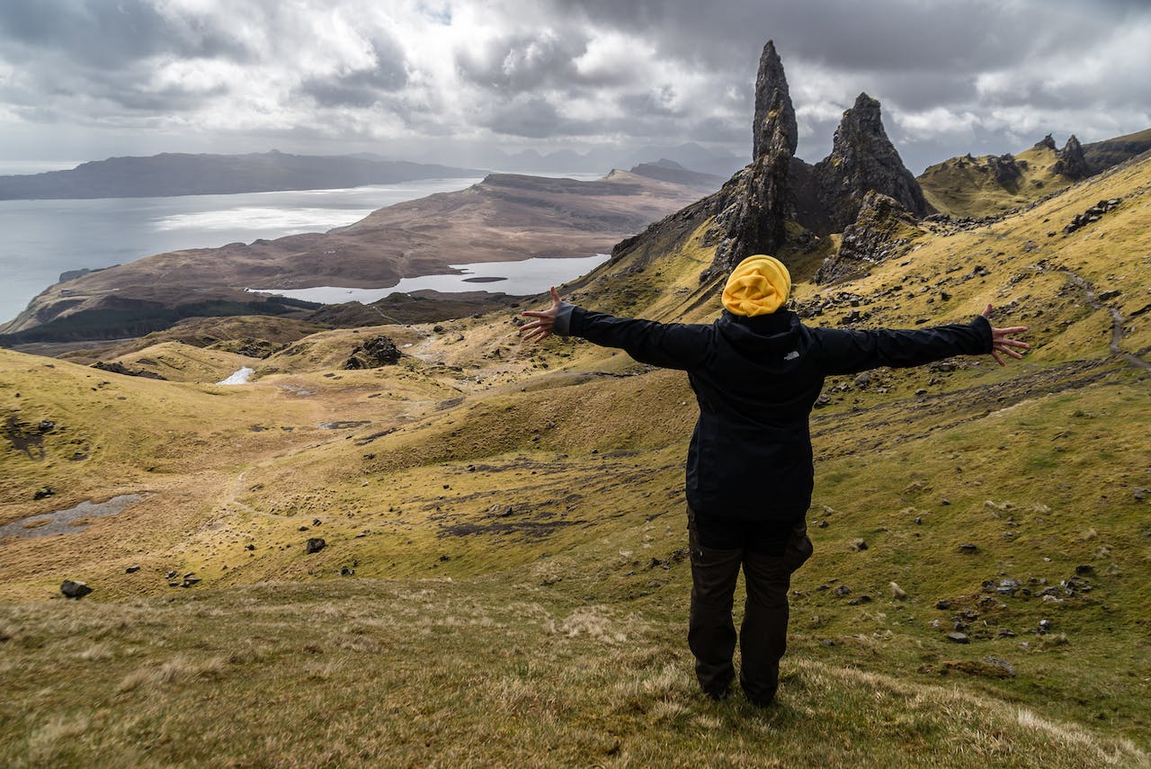 person with arms spread open on field on Scotland