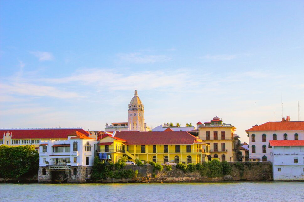 bright yellow and white historical buildings with red rooftops on the Panama canal