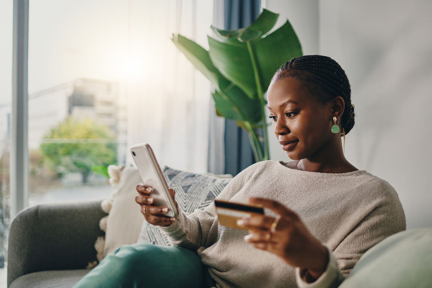 woman on phone with credit card in hand