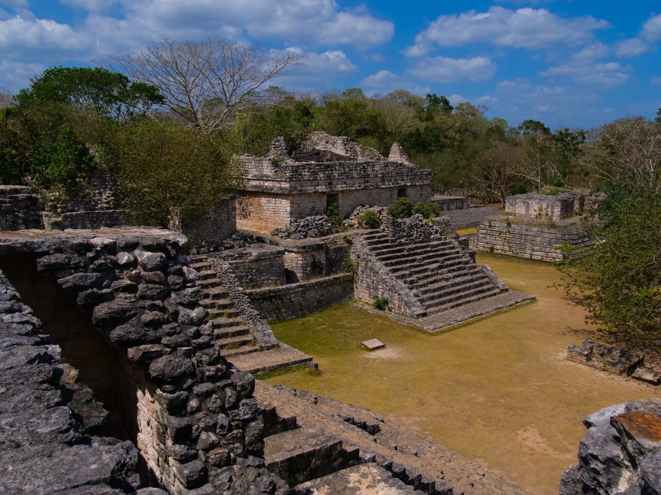 El Torre is the ancient pyramid at the center of Ek Balam.
pictured: El Torre ruins surrounded by green prominent trees and blue skies