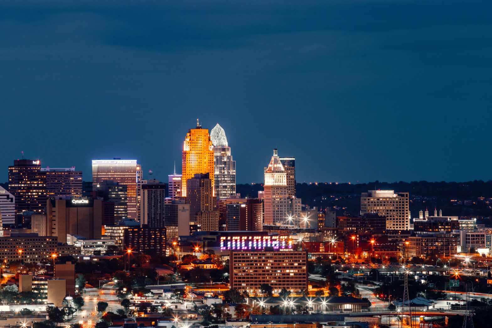 Learn more about how safe the midwestern city of Cincinnati is and what travelers should be concerned about. pictured: the night cityscape of Cincinnati with bright building lights that spell out the cities name