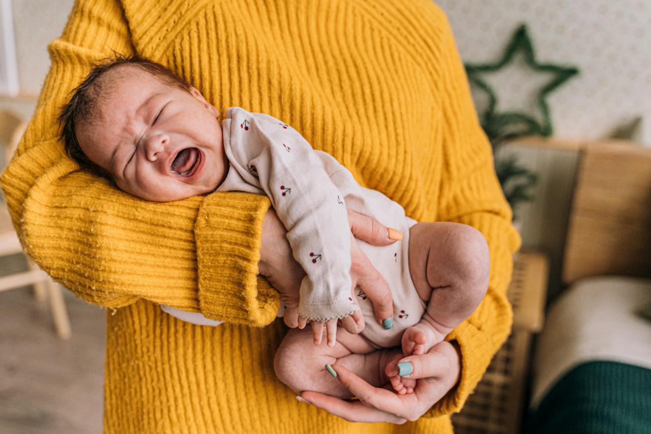 Person holding crying baby.