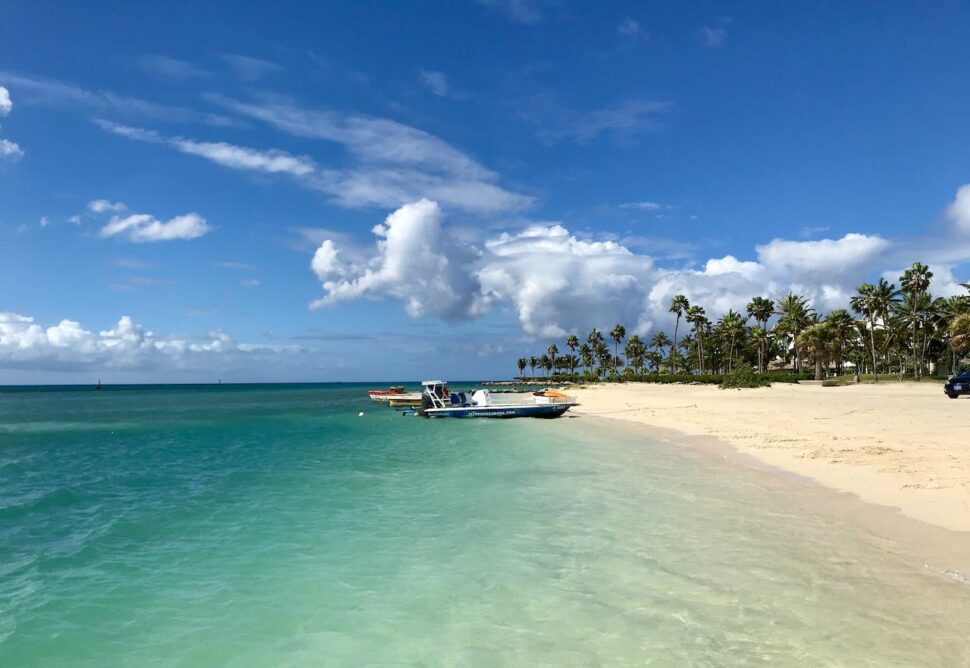 Boats stopped in the ocean on a beach in Aruba.