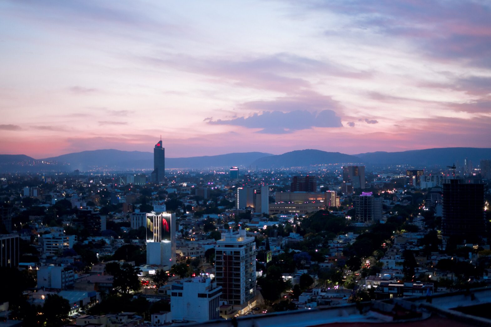 Guadalajara, Mexico is a popular city that attracts plenty of visitors but is not the safest destination to visit. pictured: the night sky line of Guadalajara lit up by urban city lights at sunset