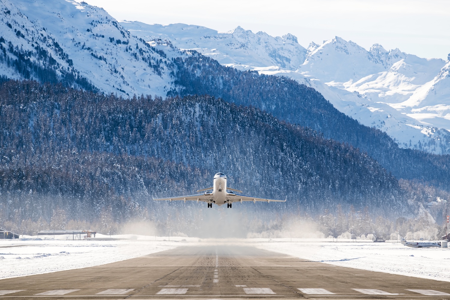 Airplane departing a snowy airfield.