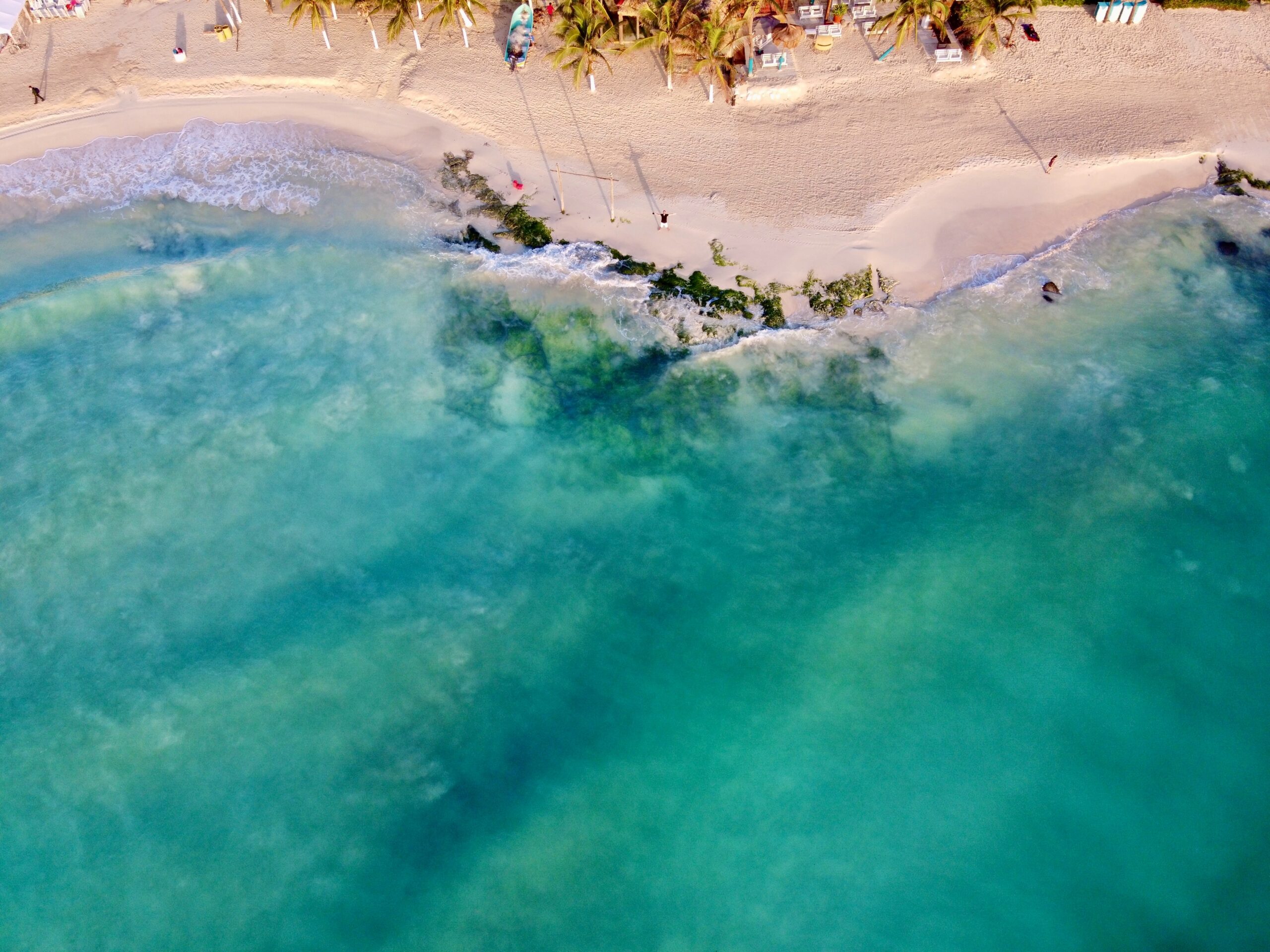 Playa del Carmen is a dream destination for travelers looking to experience a tranquil yet fun beach vacation. 
Pictured: a turquoise Playa del Carmen beach with tan sands 